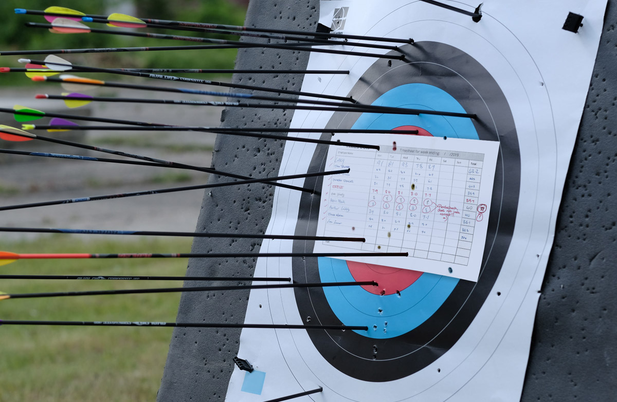 Timesheet used as a target, struck by arrows.